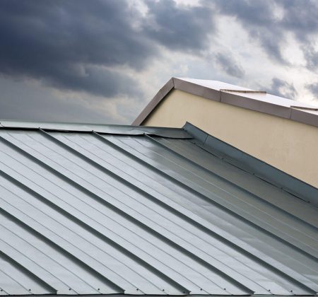 A metal roof under a dramatic stormy sky, showcasing dark clouds and an impending downpour in the background.